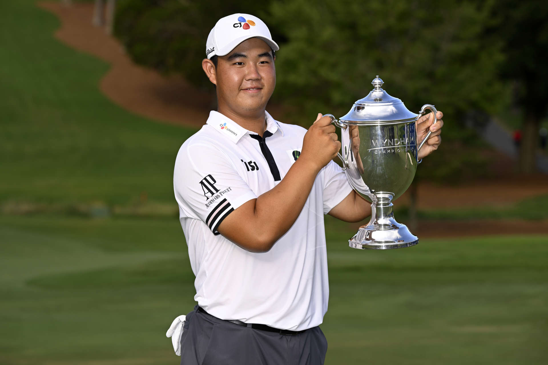 GREENSBORO, NORTH CAROLINA - AUGUST 07: Joohyung Kim of Korea poses with the trophy after putting in to win on the 18th green during the final round of the Wyndham Championship at Sedgefield Country Club on August 07, 2022 in Greensboro, North Carolina. (Photo by Eakin Howard/Getty Images)