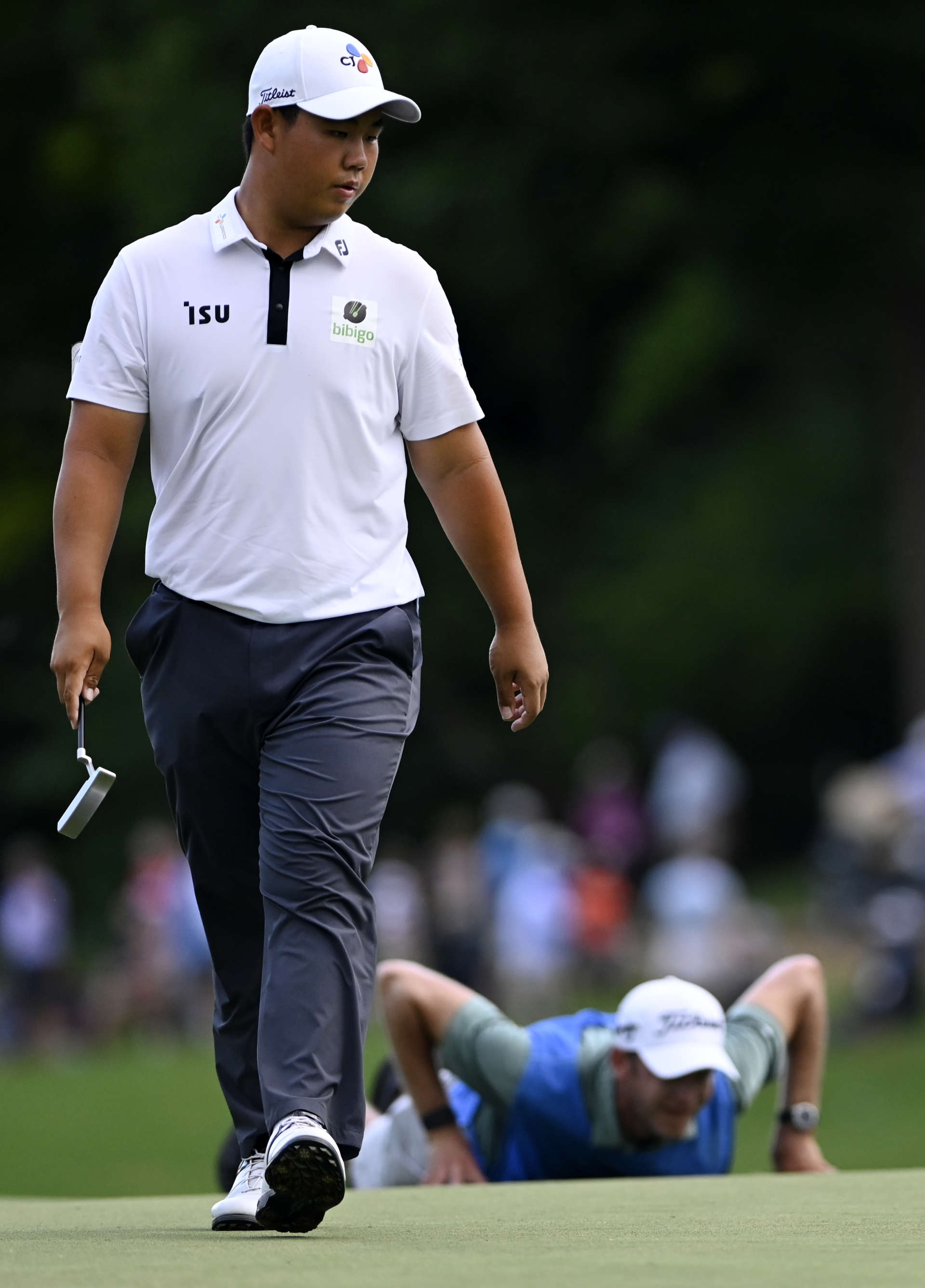 GREENSBORO, NORTH CAROLINA - AUGUST 07: Joohyung Kim of Korea walks on the 17th green as his caddie lines up a shot during the final round of the Wyndham Championship at Sedgefield Country Club on August 07, 2022 in Greensboro, North Carolina. (Photo by Eakin Howard/Getty Images)