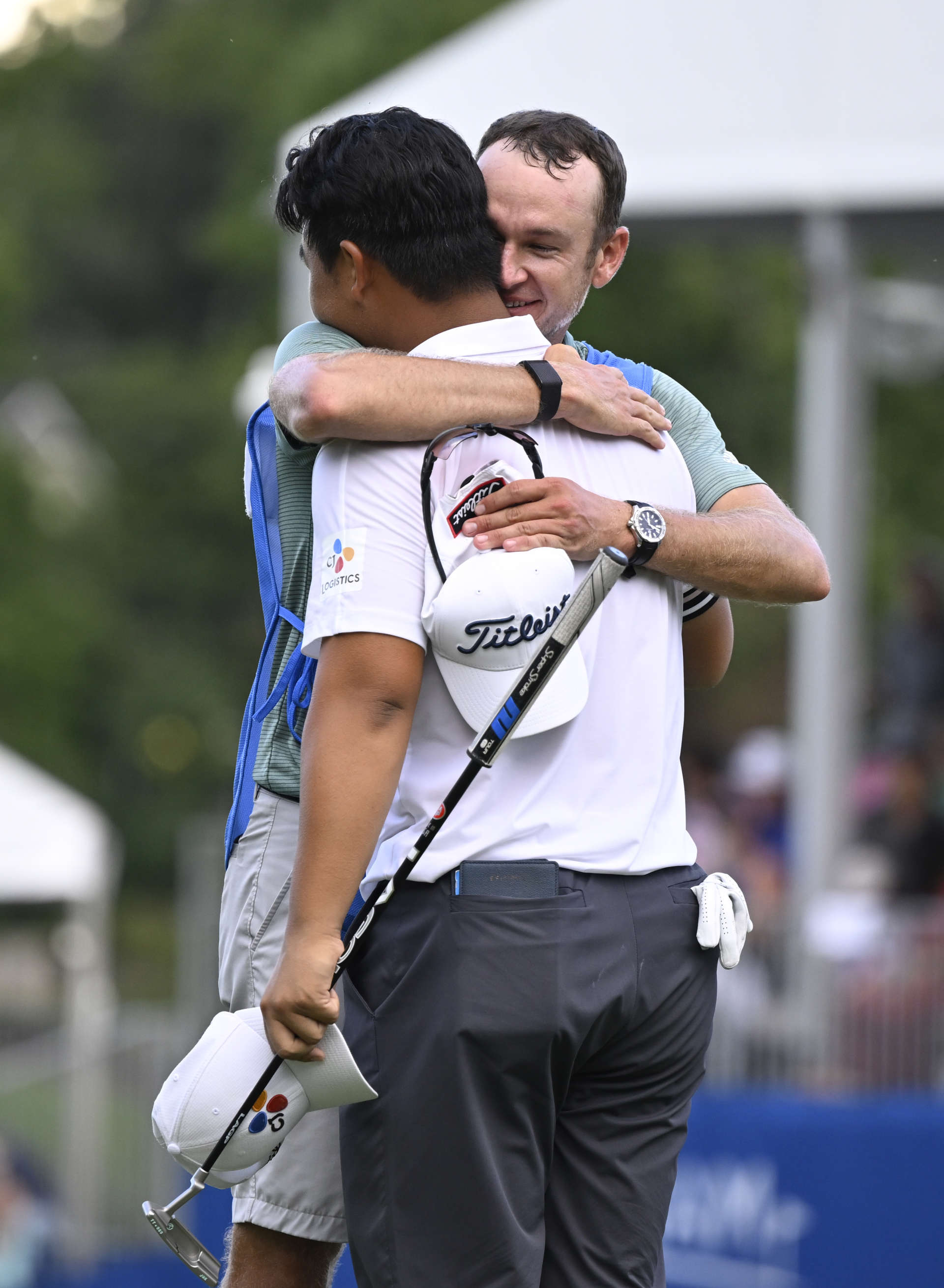 GREENSBORO, NORTH CAROLINA - AUGUST 07: Joohyung Kim of Korea celebrates with his caddie Jacob Fleck after putting in to win on the 18th green during the final round of the Wyndham Championship at Sedgefield Country Club on August 07, 2022 in Greensboro, North Carolina. (Photo by Eakin Howard/Getty Images)