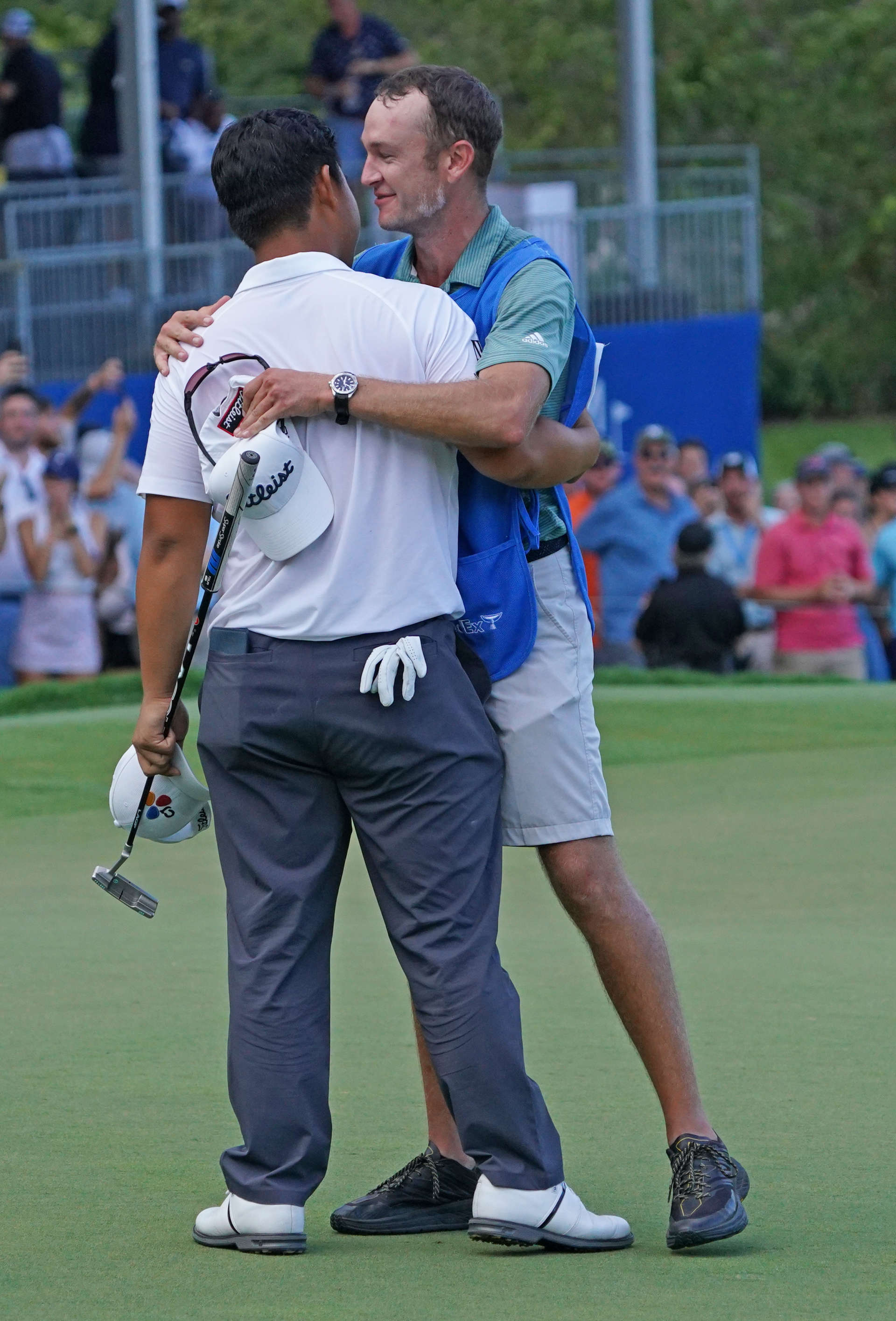 GREENSBORO, NORTH CAROLINA - AUGUST 07: Joohyung Kim of Korea celebrates with his caddie Jacob Fleck after putting in to win on the 18th green during the final round of the Wyndham Championship at Sedgefield Country Club on August 07, 2022 in Greensboro, North Carolina. (Photo by Dylan Buell/Getty Images)