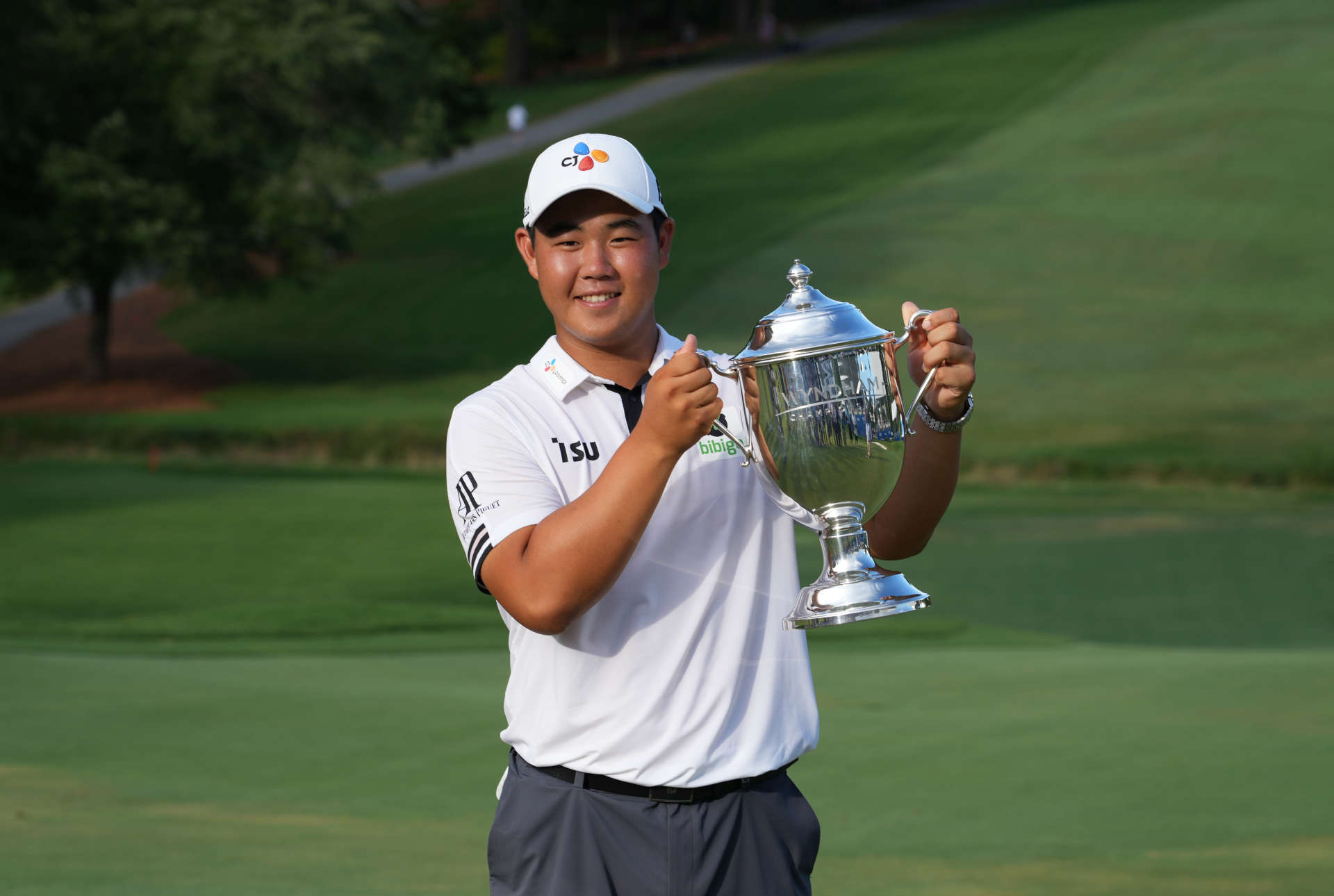 GREENSBORO, NORTH CAROLINA - AUGUST 07: Joohyung Kim of Korea poses with the trophy after putting in to win on the 18th green during the final round of the Wyndham Championship at Sedgefield Country Club on August 07, 2022 in Greensboro, North Carolina. (Photo by Dylan Buell/Getty Images)