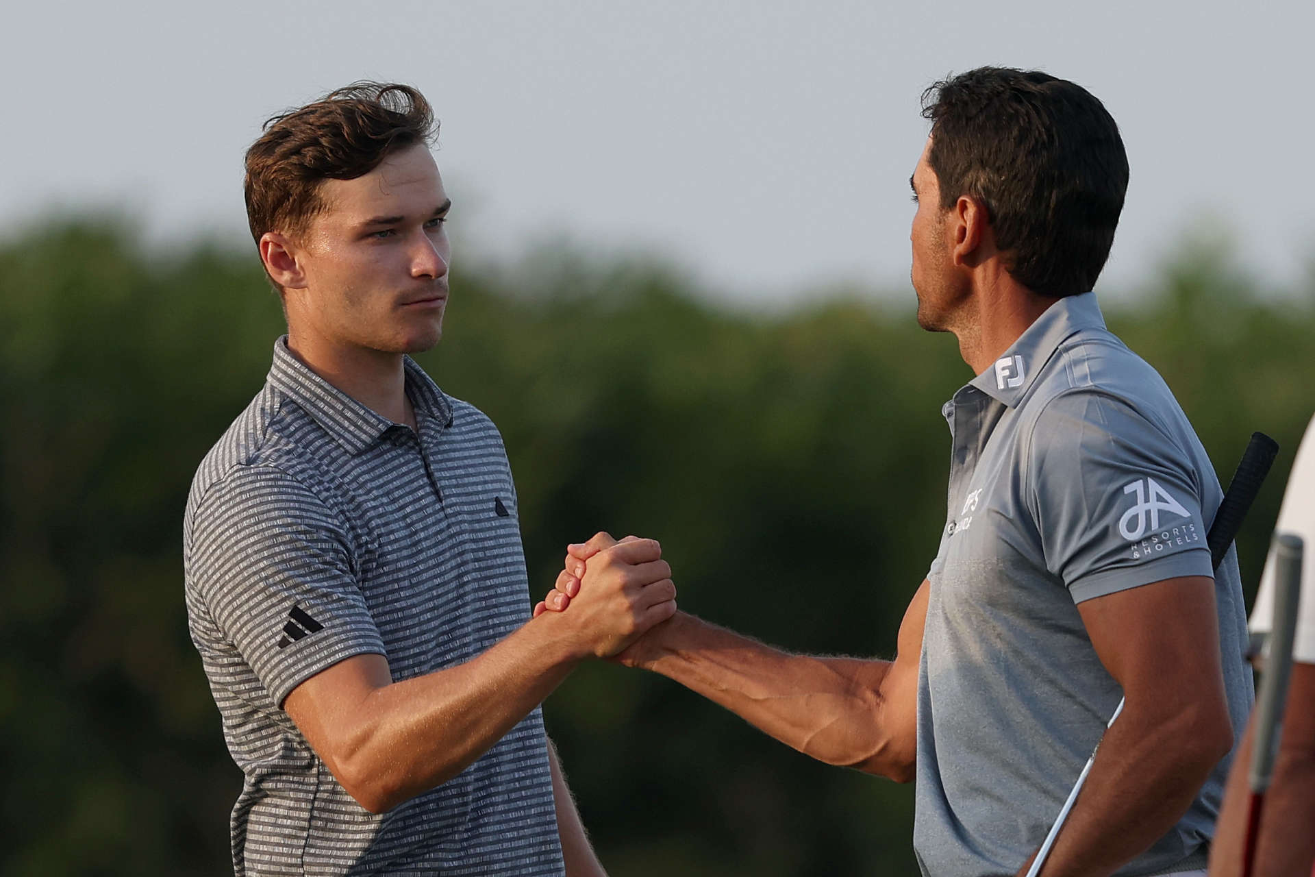 RAS AL KHAIMAH, UNITED ARAB EMIRATES - FEBRUARY 03: Rasmus Hojgaard of Denmark and Rafa Cabrera Bello of Spain shake hands after finishing their rounfd on the 18th Hole on Day Two of the Ras Al Khaimah Championship at Al Hamra Golf Club on February 03, 2023 in Ras al Khaimah, United Arab Emirates. (Photo by Warren Little/Getty Images)