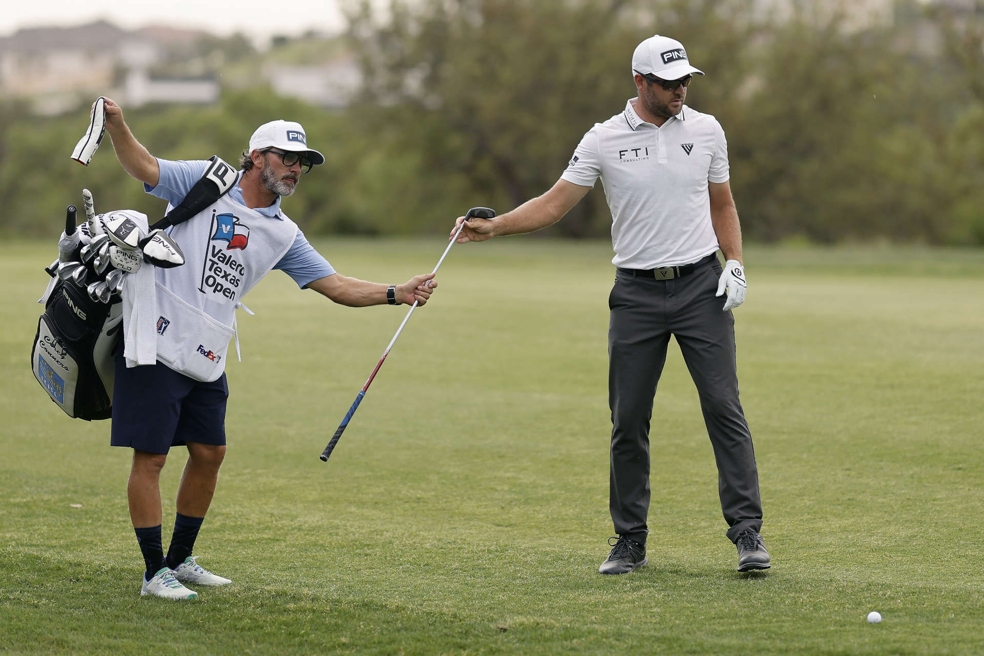 SAN ANTONIO, TEXAS - APRIL 01: Corey Conners of Canada exchanges clubs with his caddie on the 18th hole during the third round of the Valero Texas Open at TPC San Antonio on April 01, 2023 in San Antonio, Texas. (Photo by Mike Mulholland/Getty Images)