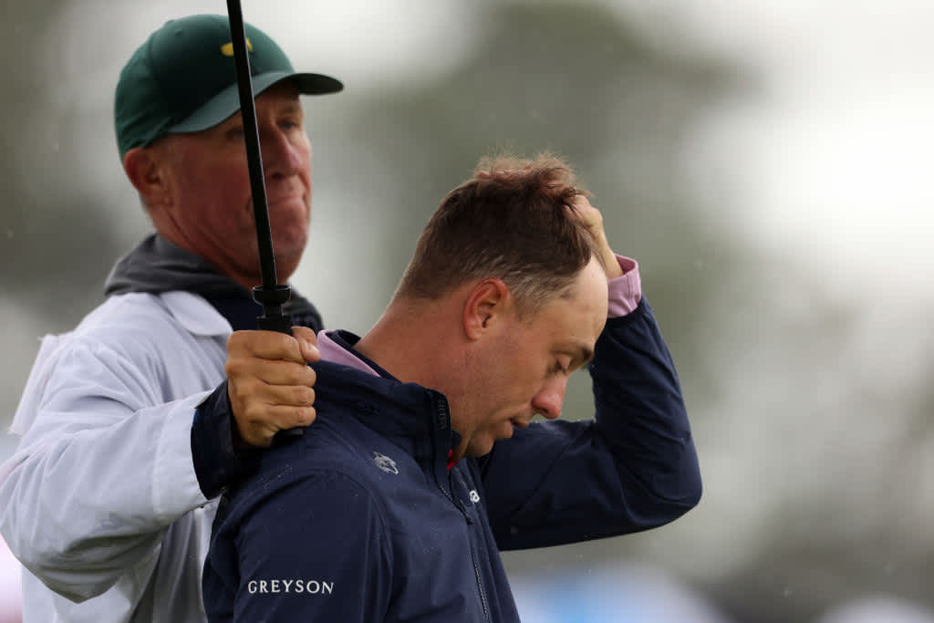 AUGUSTA, GEORGIA - APRIL 08: Justin Thomas of the United States and his caddie Jim 'Bones' Mackay react to his bogey on the 18th green during the continuation of the weather delayed second round of the 2023 Masters Tournament at Augusta National Golf Club on April 08, 2023 in Augusta, Georgia. (Photo by Christian Petersen/Getty Images)