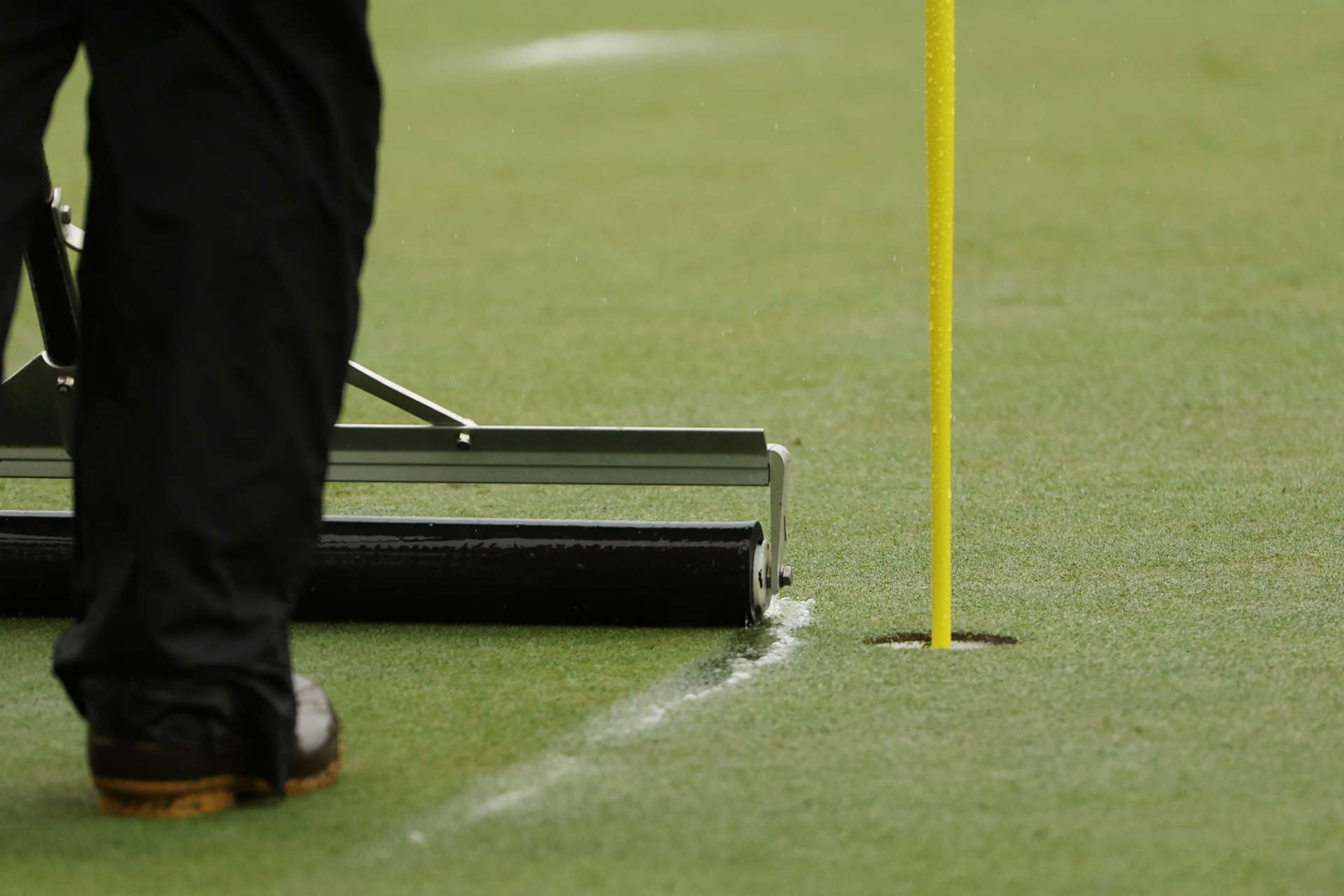AUGUSTA, GEORGIA - APRIL 08: A greenskeeper clears water from the seventh green during the third round of the 2023 Masters Tournament at Augusta National Golf Club on April 08, 2023 in Augusta, Georgia. (Photo by Patrick Smith/Getty Images)