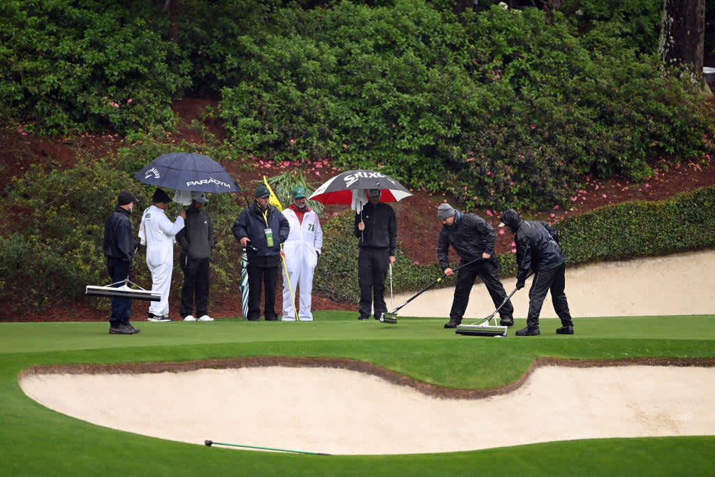 AUGUSTA, GEORGIA - APRIL 08: Xander Schauffele of the United States and Keegan Bradley of the United States talk with a rules official as greenskeeper remove water from the 12th green during the third round of the 2023 Masters Tournament at Augusta National Golf Club on April 08, 2023 in Augusta, Georgia. (Photo by Ross Kinnaird/Getty Images)