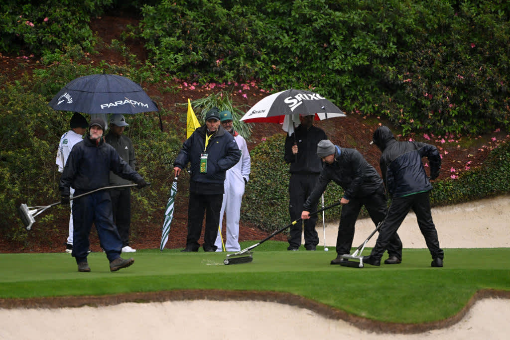 AUGUSTA, GEORGIA - APRIL 08: Xander Schauffele of the United States and Keegan Bradley of the United States talk with a rules official as greenskeeper remove water from the 12th green during the third round of the 2023 Masters Tournament at Augusta National Golf Club on April 08, 2023 in Augusta, Georgia. (Photo by Ross Kinnaird/Getty Images)
