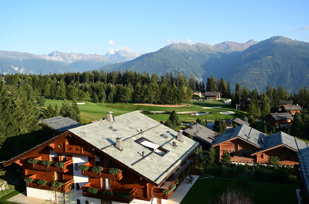 Umgeben von traumhaften Schweizer Häusern und den Alpen liegt Loch 14 des Golf Clubs Crans-sur-Sierre.