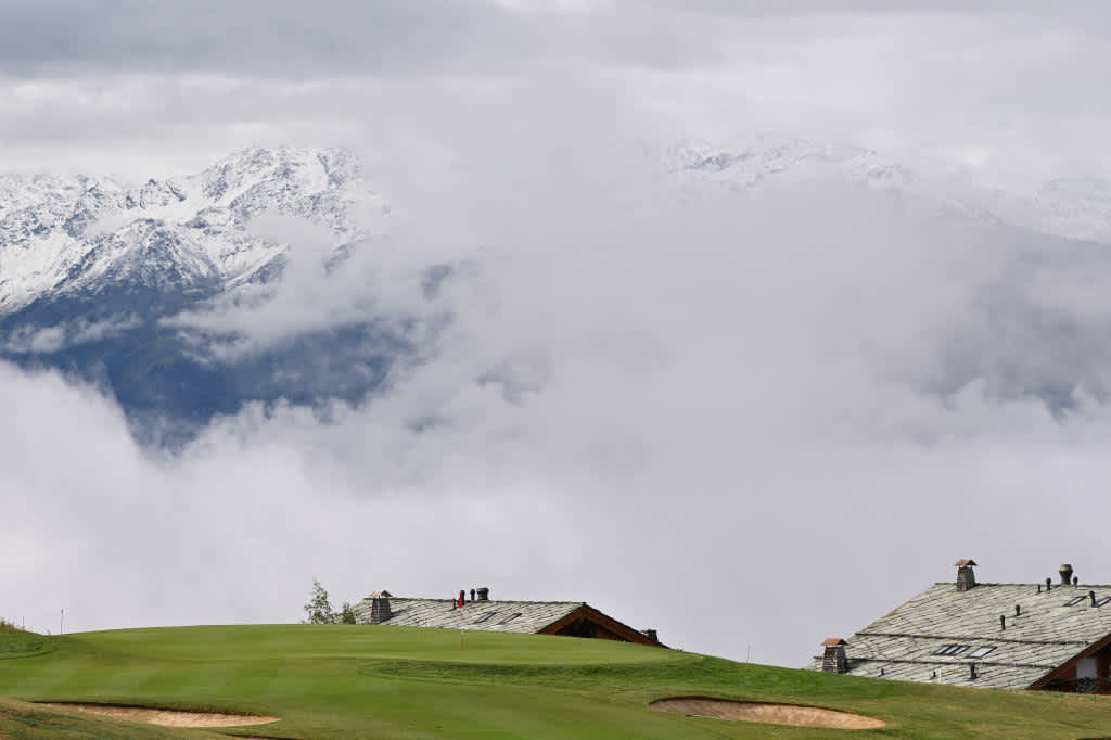Die schneebedeckten Alpen tauchen zwischen den Wolken auf. Dieser Ausblick lässt sich am siebten Loch bestaunen.