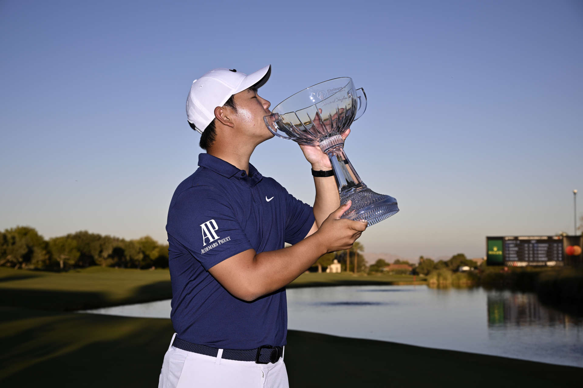 LAS VEGAS, NEVADA - OCTOBER 15: Tom Kim of South Korea kisses the trophy after putting in to win on the 18th green during the final round of the Shriners Children's Open at TPC Summerlin on October 15, 2023 in Las Vegas, Nevada. (Photo by Orlando Ramirez/Getty Images)