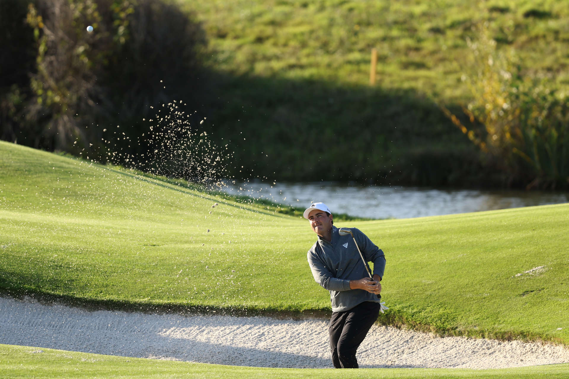 GUYANCOURT, FRANCE - OCTOBER 11: Aaron Cockerill of Canada plays his second shot on the 18th hole out of the bunker on day two of the FedEx Open de France 2024 at Le Golf National on October 11, 2024 in Guyancourt, France. (Photo by Warren Little/Getty Images)