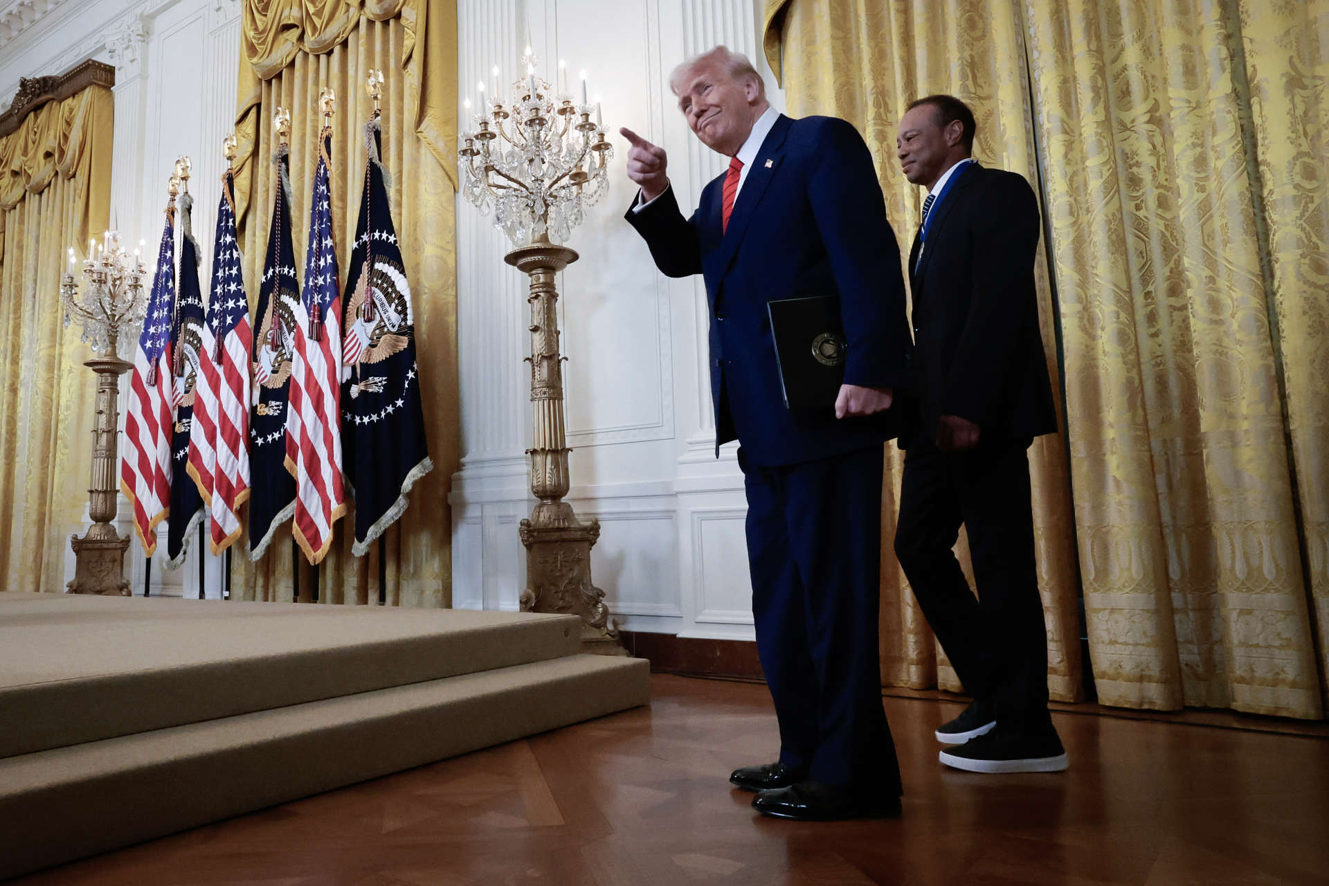 WASHINGTON, DC - FEBRUARY 20: U.S. President Donald Trump and golf legend Tiger Woods arrive for a reception honoring Black History Month in the East Room of the White House on February 20, 2025 in Washington, DC. The Black History Month celebration comes as Trump has signed a series of executive orders ending federal diversity, equity and inclusion (DEI) programs and cutting funding to schools and Universities that do not cut DEI programs. (Photo by Win McNamee/Getty Images)