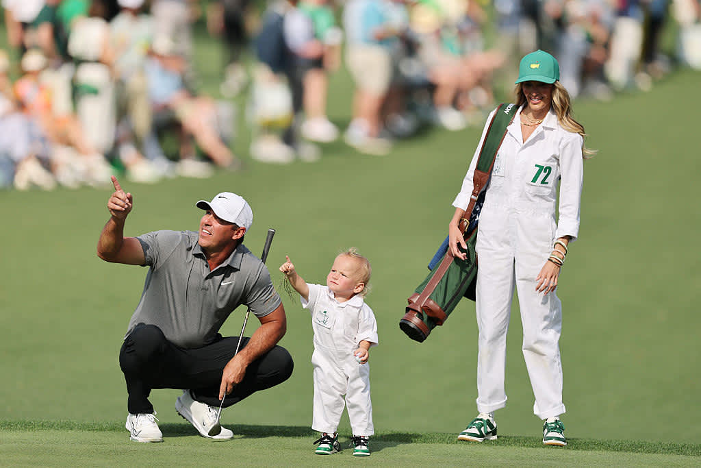 AUGUSTA, GEORGIA - APRIL 09: Brooks Koepka of the United States gestures alongside his wife, Jena Sims, and their son, Crew Sims Koepka, during the Par Three Contest prior to the 2025 Masters Tournament at Augusta National Golf Club on April 09, 2025 in Augusta, Georgia. (Photo by Michael Reaves/Getty Images)