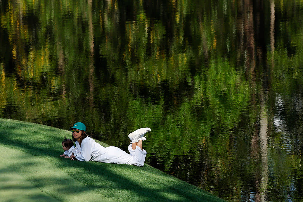 AUGUSTA, GEORGIA - APRIL 09: Wife of Rafael Campos of Puerto Rico, Stephanie Casanova, lies with their daughter, Paola Isabel, on the ninth hole during the Par Three Contest prior to the 2025 Masters Tournament at Augusta National Golf Club on April 09, 2025 in Augusta, Georgia. (Photo by Harry How/Getty Images)