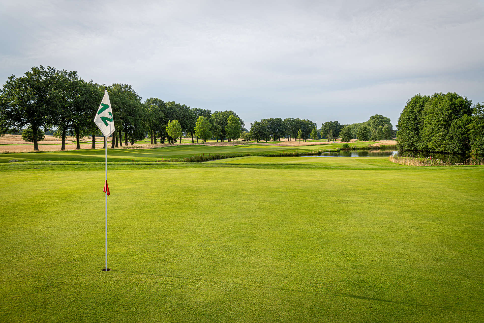 Schöne Aufnahme der zwölften Golfbahn mit Wasserhindernis, welche die Herausforderung und Vielseitigkeit des Golfplatzes zeigt.