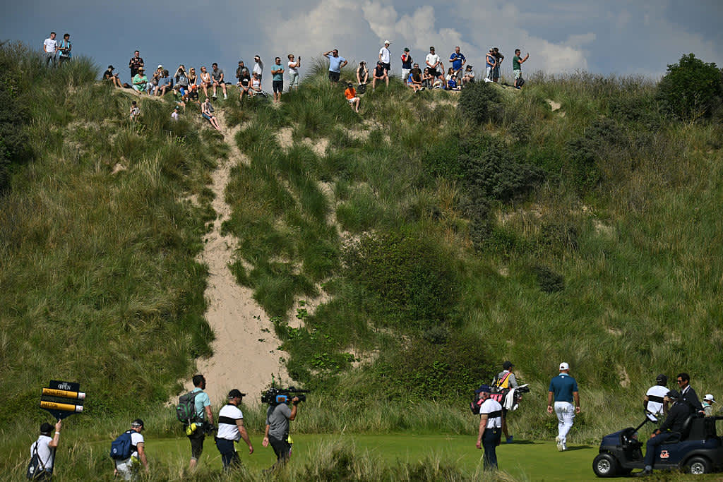 Spectators get a free view of the golf from the top of the dunes on day four of the 153rd Open Championship at Royal Portrush golf club in Northern Ireland on July 20, 2025. (Photo by ANDY BUCHANAN / AFP) / RESTRICTED TO EDITORIAL USE (Photo by ANDY BUCHANAN/AFP via Getty Images)