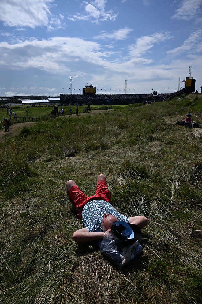 A spectator relaxes in the sunshine on day four of the 153rd Open Championship at Royal Portrush golf club in Northern Ireland on July 20, 2025. (Photo by Glyn KIRK / AFP) / RESTRICTED TO EDITORIAL USE (Photo by GLYN KIRK/AFP via Getty Images)