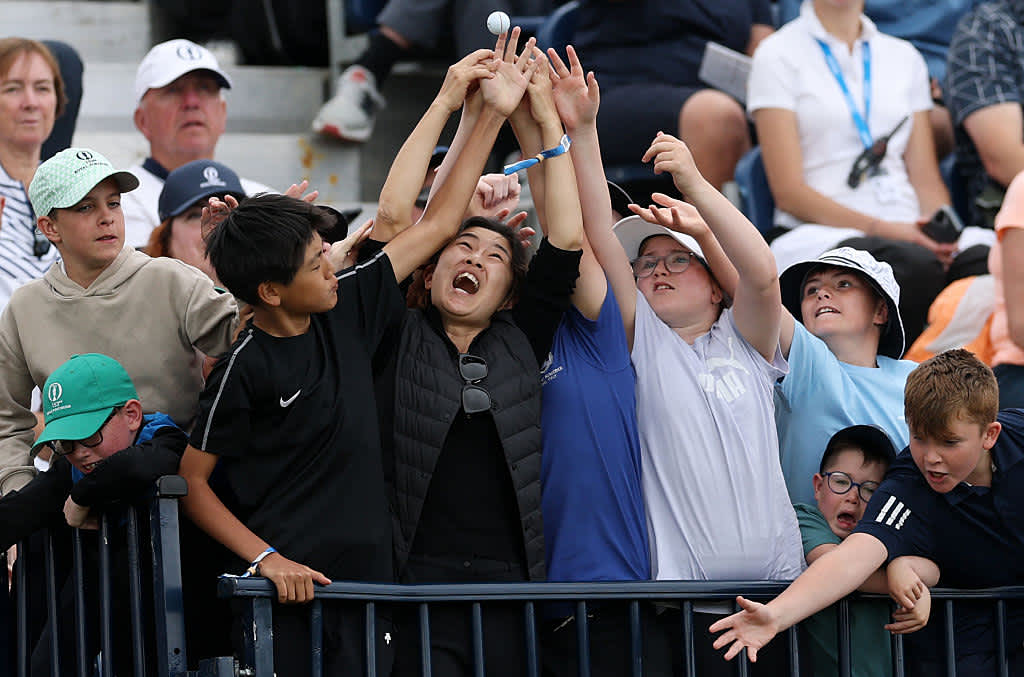 PORTRUSH, NORTHERN IRELAND - JULY 18: Fans try to catch a golf ball on the 18th hole during day two of The 153rd Open Championship at Royal Portrush Golf Club on July 18, 2025 in Portrush, Northern Ireland. (Photo by Richard Heathcote/Getty Images)