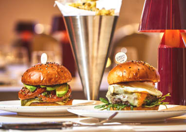 Two burgers on a plate with chips