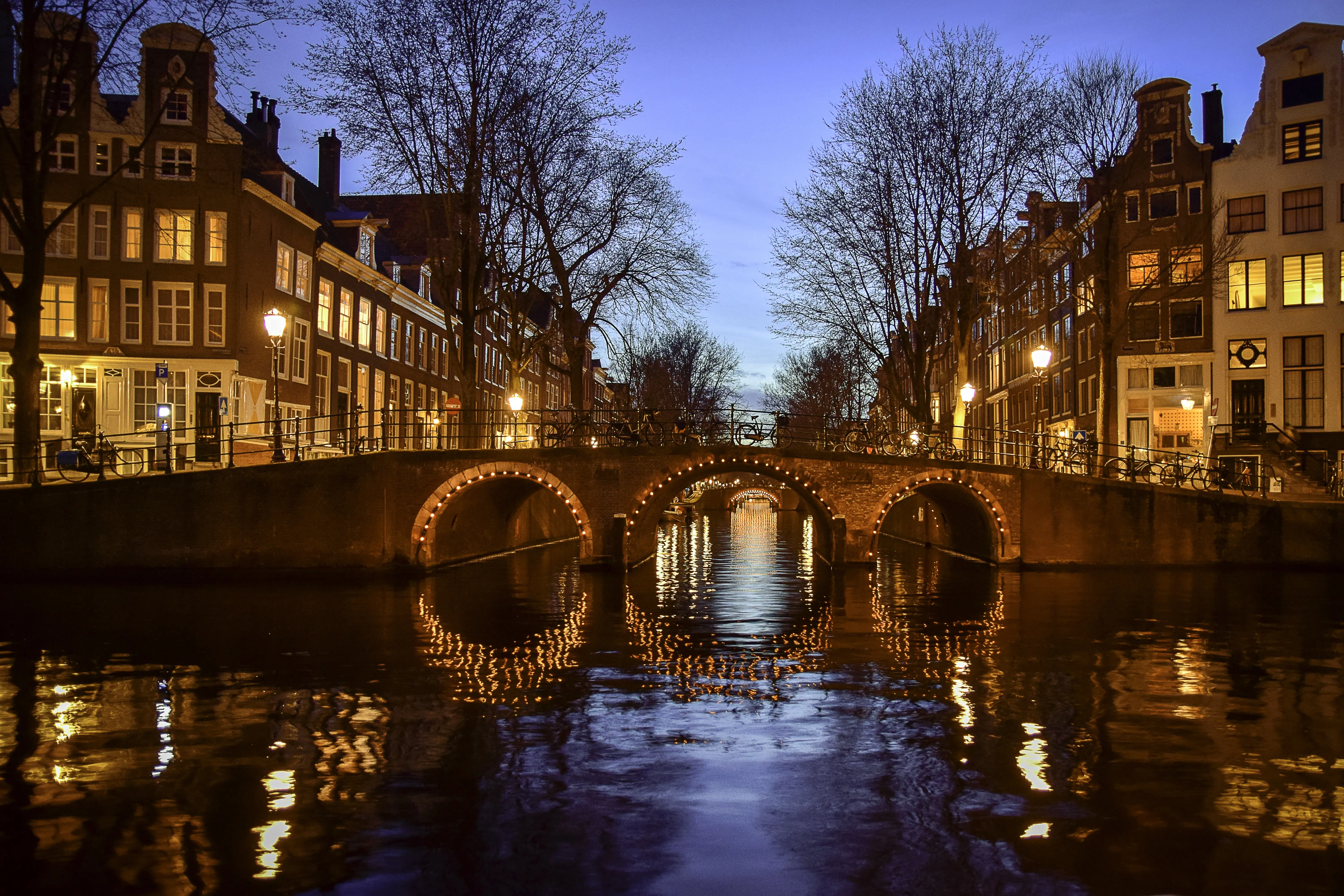 A Lit-Up Stone Bridge Spanning a Canal at Night