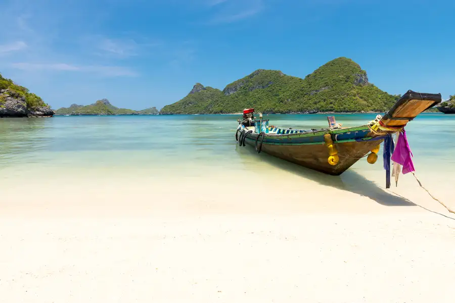 Longtail Boat Sits on a White Sandy Beach