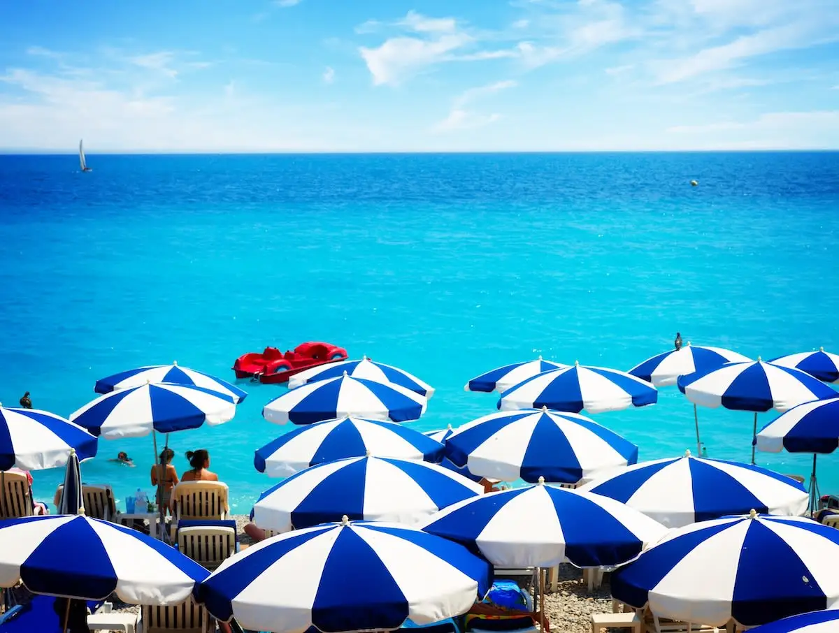 Blue and white beach umbrellas and turquoise sea