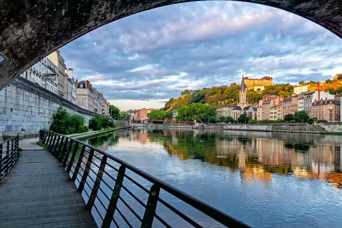 path along river under bridge in lyon