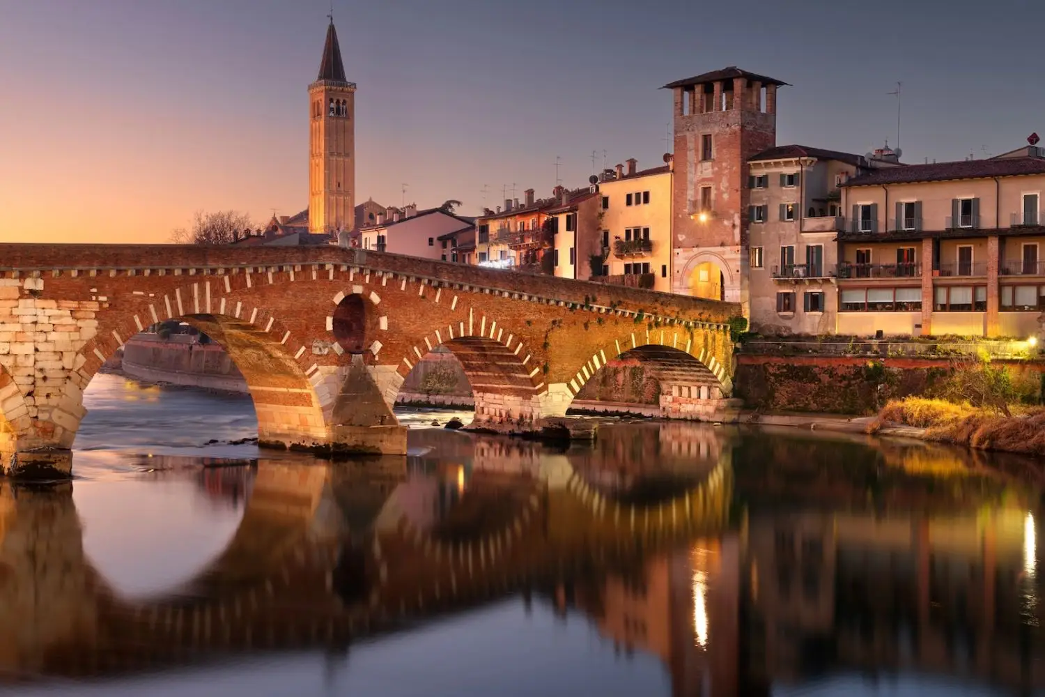 brick bridge and river with skyline in verona