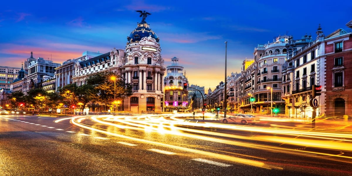 Madrid's Gran Via Bustles at Dusk in front of the iconic Metrópolis building