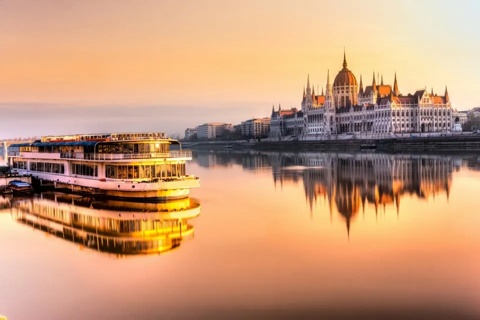 Sunset view of the Danube River with a river boat and Hungarian Parliament in Budapest