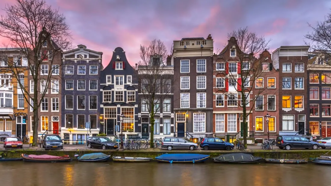 The homes of Amsterdam line up above a canal