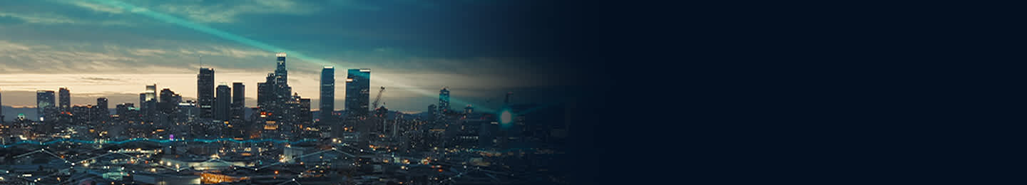 Evening cityscape featuring high-rise buildings in the background, with light streaks connecting smaller buildings below — symbolizing how Samsung B2B Integrated Offering delivers consolidated and connected solutions.