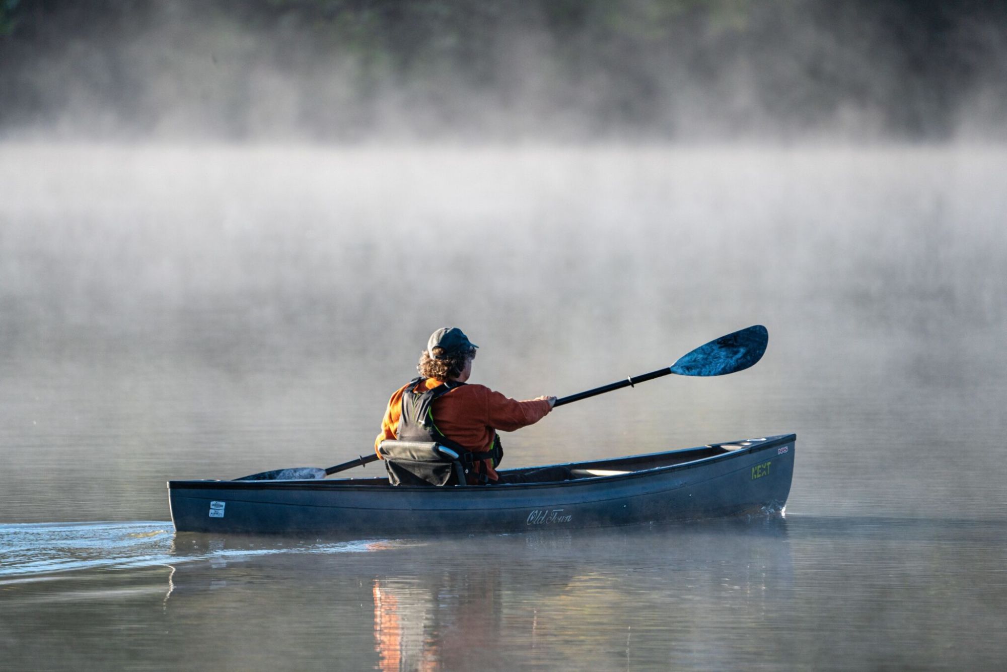 Canoer on foggy lake