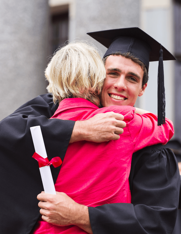 Queensland graduate in academic gown hugging mother
