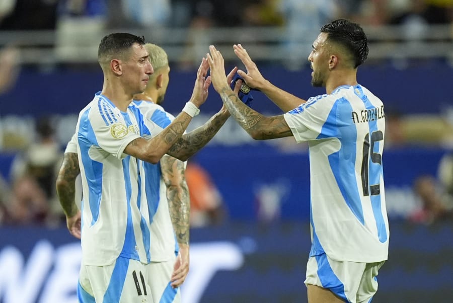 Argentina's Angel Di Maria, left, greets teammate Nicols Gonzalez as he leaves the field during the Copa America final soccer match against Colombia in Miami Gardens, Fla., Monday, July 15, 2024. (AP Photo/Rebecca Blackwell)