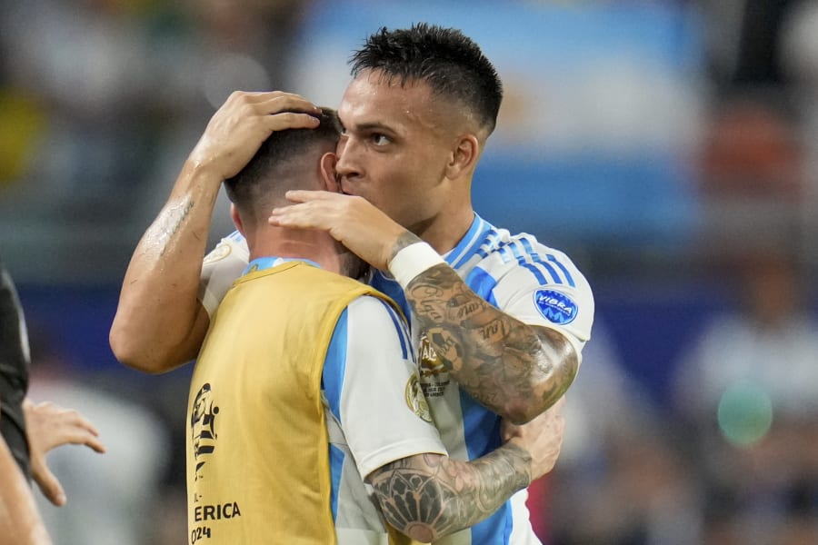 Argentina's Lautaro Martnez embraces Lionel Messi after scoring his side's opening goal against Colombia during the Copa America final soccer match in Miami Gardens, Fla., Sunday, July 14, 2024. (AP Photo/Julio Cortez)