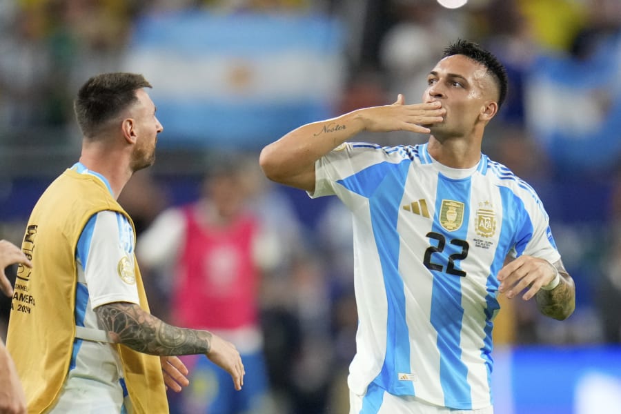 Argentina's Lautaro Martnez (22) celebrates with Lionel Messi after scoring his side's opening goal against Colombia during the Copa America final soccer match in Miami Gardens, Fla., Sunday, July 14, 2024. (AP Photo/Julio Cortez)