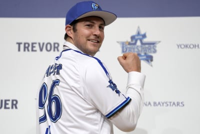 Trevor Bauer with his new uniform and cap of Yokohama DeNA BayStars poses  for photographers during a photo session of the news conference Friday,  March 24, 2023, in Yokohama, near Tokyo. (AP