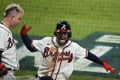 Atlanta Braves shortstop Dansby Swanson walks in the dugout during