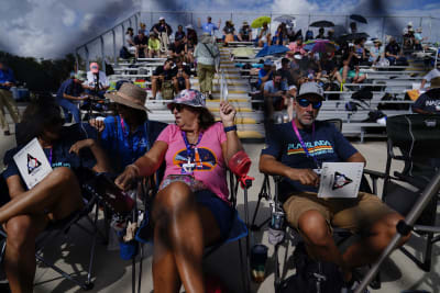 Spectators watch a sunrise from the Max Brewer Bridge while waiting to view  the launch on Pad 39B for the Artemis I mission to orbit the moon at the  Kennedy Space Center