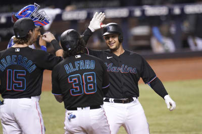 Miami Marlins manager Don Mattingly, left, and a trainer, right