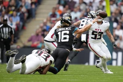 FILE - Jacksonville Jaguars quarterback Trevor Lawrence (16) runs onto the  field for an NFL football game between the Miami Dolphins and the Jaguars  at the Tottenham Hotspur stadium in London on