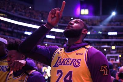 Kobe Bryant puts down the microphone after he addresses the crowd