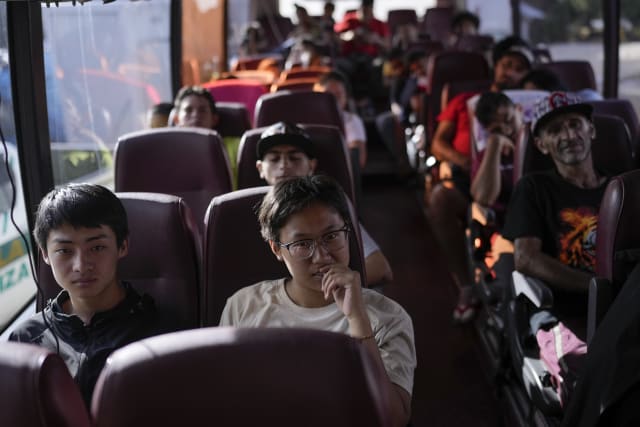 La migrante china Liu Tiantian, segunda desde la izquierda, sentada en un autobs que trasladar a los migrantes hasta Costa Rica despus de cruzar el Tapn del Darin con su padre y su hermano en Lajas Blancas, Panam, el jueves 27 de junio de 2024. (Foto AP/Matas Delacroix)
