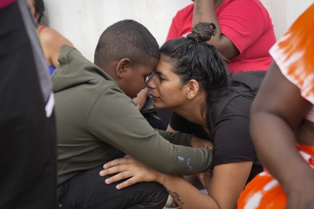 La migrante venezolana Nelsy Zavala, a la derecha, abraza a un chico migrante venezolano Yeikel Mojica, a quien conoci mientras cruzaba el Tapn del Darin y dice que era como un hermano pequeo para ella, en un campamento temporal en Lajas Blancas, Panam, el jueves 27 de junio de 2024. ( Foto AP/Matas Delacroix)