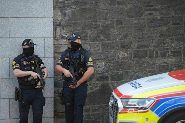 Law enforcement officials escorting a suspect from an aircraft onto the tarmac in Dublin.
