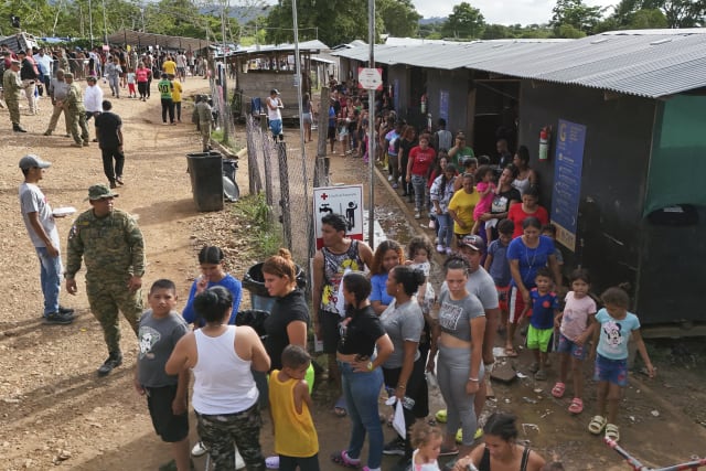 Migrantes hacen fila para recibir alimentos en un campamento temporal despus de cruzar el Tapn del Darin desde Colombia en Lajas Blancas, Panam, el jueves 27 de junio de 2024. (Foto AP/Matas Delacroix)