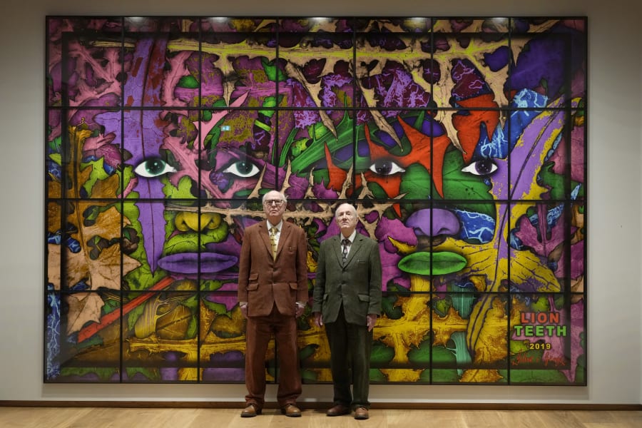 Artists Gilbert and George stand with their artwork called Lion Teeth in their exhibition called The Paradisical Pictures at the opening of The Gilbert & George Centre in east London, Friday, March 24, 2023. (AP Photo/Kirsty Wigglesworth)