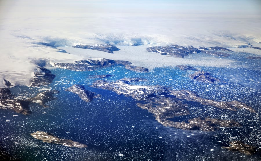 FILE - Icebergs float in a fjord after calving off from glaciers on the Greenland ice sheet in southeastern Greenland, Aug. 3, 2017. The Greenland ice sheet, the second largest body of ice in the world which covers roughly 80 percent of the country, has been melting and its glaciers retreating at an accelerated pace in recent years due to warmer temperatures. If all of that ice melts, sea levels will rise by several meters, though there will be regional differences. (AP Photo/David Goldman, File)