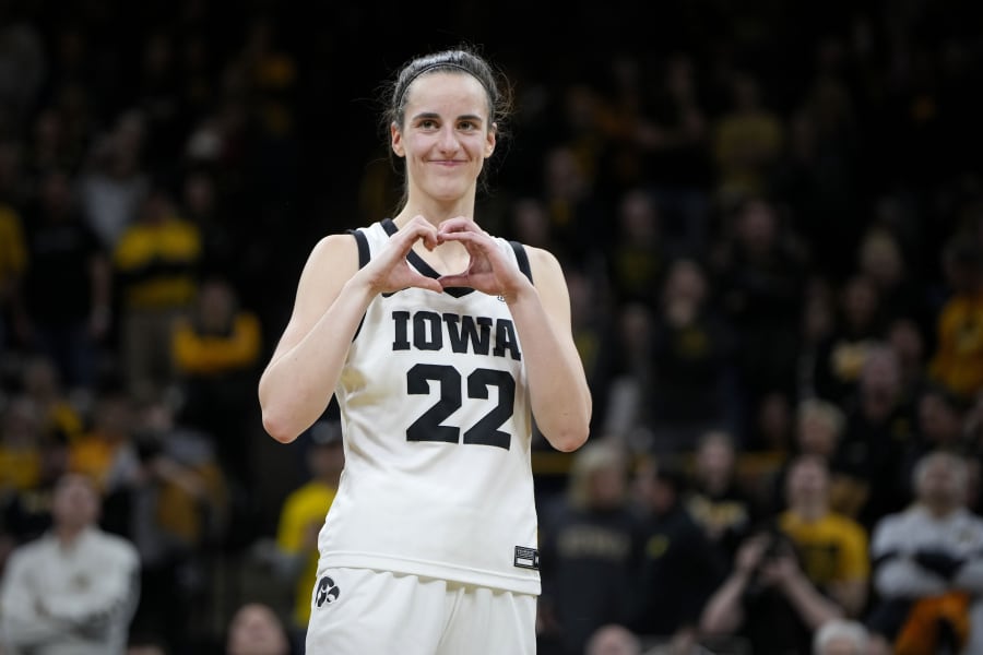 Iowa guard Caitlin Clark makes a heart gesture after the team's NCAA college basketball game against Michigan, Thursday, Feb. 15, 2024, in Iowa City, Iowa. Clark broke the NCAA women's career scoring record. (AP Photo/Matthew Putney)